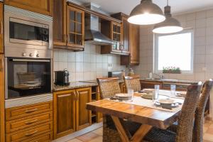 uma grande cozinha com uma mesa de madeira e cadeiras em Azor Beach Lodge em Ponta Delgada