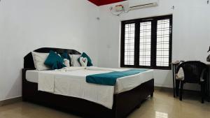 a bedroom with a bed and a table and a window at Tech City Hotel Trivandrum in Trivandrum