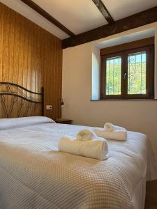 a bedroom with a bed with towels on it at Rincón de Laciana in Caboalles de Abajo