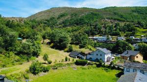 a village on a hill with houses and trees at Rincón de Laciana in Caboalles de Abajo