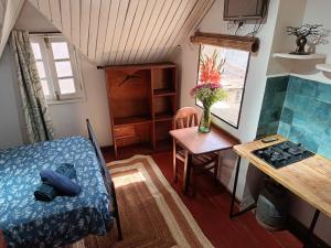 a small room with a table and a kitchen with a stove at La lanterne in Antananarivo