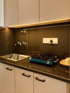 a kitchen counter with a stove and a sink at Skyline Zirakpur in Zirakpur