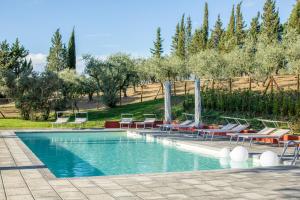a swimming pool with chairs and tables and trees at Glamping Poggio Nardini in Montelupo Fiorentino