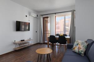 a living room with a blue couch and a table at Transilvaniya Apartments in Sozopol