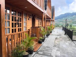 a courtyard of a building with potted plants on it at Better House & Cabin Dieng in Diyeng