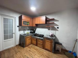 a kitchen with a sink and a stove in it at Better House & Cabin Dieng in Diyeng