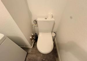 a bathroom with a toilet with a roll of toilet paper on it at Studio central équipé in Compiègne