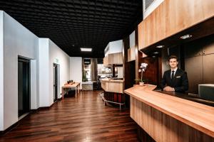 a man in a suit standing at a bar at REDBERRY Hotel - Düsseldorf - Neuss in Neuss