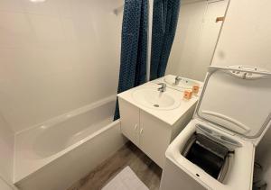 a white bathroom with a sink and a bath tub at Studio central équipé in Compiègne