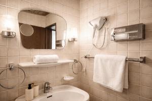 a bathroom with a sink and a mirror at REDBERRY Hotel - Düsseldorf - Neuss in Neuss