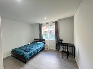a bedroom with a bed and a desk and a window at Spacious Queen Room - Train Station - NG5 in Guildford