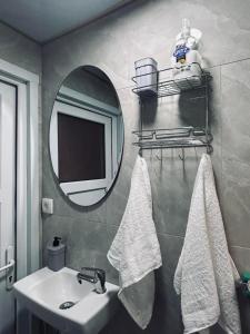 a bathroom with a sink and a mirror and towels at Ognjiste Komarnice in Komarnica +14 photos