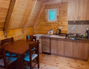 a kitchen with a wooden table and a table and a dining room at Ognjiste Komarnice in Komarnica