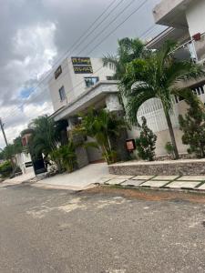 a building with palm trees in front of a street at EL and LOUNGE in Accra