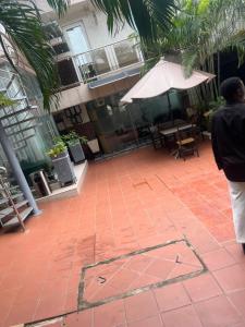 a person standing in a courtyard with an umbrella at EL and LOUNGE in Accra