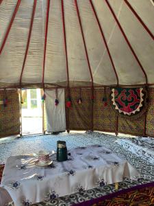 a tent with a table with a tea pot on it at D&N Karakol in Karakol