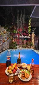 a table with plates of food next to a swimming pool at Sunshine villa thuan an in Hue