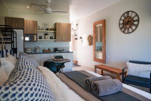 a living room with a bed and a kitchen at The Dunes Haven studio in Keurboomstrand