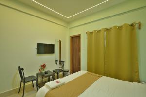 a bedroom with a bed and a table and chairs at Kaizen Stay-Inn in Jowai