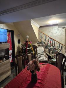 a dining room with a table and a christmas tree at Casa Nicolas Busteni in Buşteni