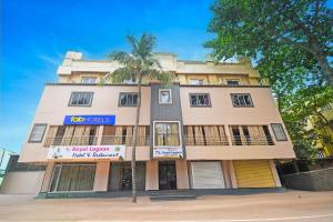 a building with a palm tree in front of it at FabHotel Royal Lagoon in Bhubaneshwar