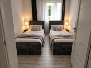 two twin beds in a room with a window at Apartament w Centrum Prudnika in Prudnik