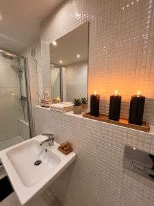 a bathroom with a sink and two candles on a shelf at Apartament w Centrum Prudnika in Prudnik