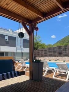 a patio with a swing and chairs and a pool at Vila Dar Selam halal-friendly in Mostar
