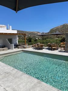 a swimming pool with a table and chairs in a house at Ninemia Naxos Suites in Naxos Chora