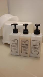 a group of four bottles of soap and a phone at Bears Cottages in Furano