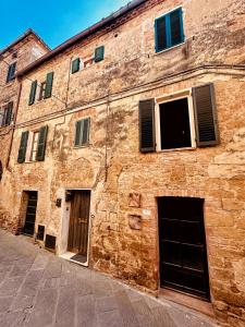 an old brick building with doors and windows at La Casina Room in Castelmuzio