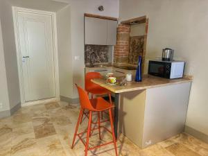 a small kitchen with a counter and two stools at La Casina Room in Castelmuzio