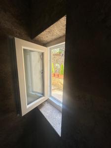 an open window with a view of a yard at La Casina Room in Castelmuzio
