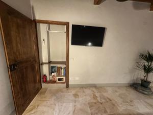 a room with a door and a television on the wall at La Casina Room in Castelmuzio