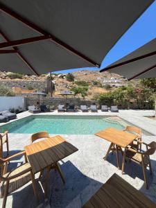 a pool with a table and chairs and an umbrella at Ninemia Naxos Suites in Naxos Chora