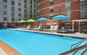a swimming pool with lounge chairs and umbrellas at Hilton Garden Inn Atlanta Midtown in Atlanta