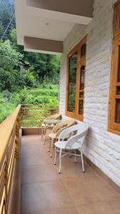 a patio with chairs and tables on a building at Himalayan Hideaway Homestay in Kasol +21 photos