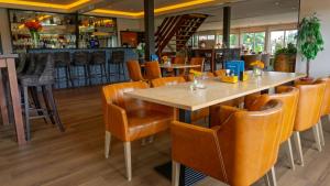 a restaurant with a table and chairs and a bar at Hotel de Harmonie in Giethoorn +50 photos