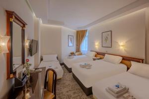 a hotel room with two beds and a television at Al Shohada by Palm Rich Makkah in Mecca +77 photos