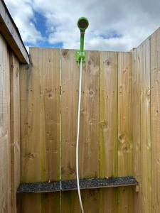 a wooden fence with a green meter on it at the buttercup shed in Lochcarron