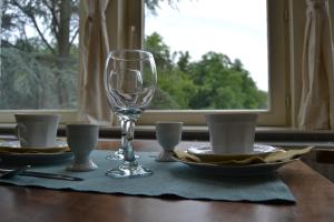 a table with a wine glass and plates on it at Château d'Harnoy in Yvoir