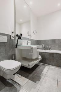 a bathroom with a toilet and a sink at Grimm´s Berlin Potsdam in Teltow