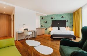 a hotel room with a bed and a couch at Grimm´s Berlin Potsdam in Teltow