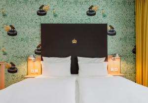 a hotel room with two beds and a headboard at Grimm´s Berlin Potsdam in Teltow