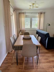 a dining room table with chairs and a blue couch at Toni's house in Bled