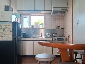a small kitchen with a table and a refrigerator at Bears Cottages in Furano