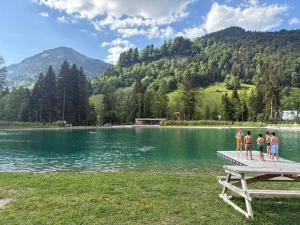 a group of people standing on a dock in a lake at Les Caribous - Lac 1 min, Espace Diamant, Megeve in Praz-sur-Arly