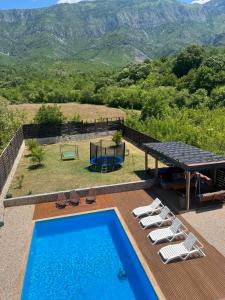 a pool with chairs and a table and a view of mountains at Vila Dar Selam halal-friendly in Mostar