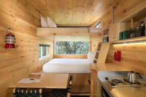 a small kitchen with a bed in a tiny house at Postcard Cabins Big Bear, Outdoor Collection by Marriott Bonvoy in Running Springs +49 photos