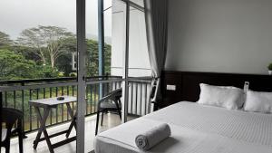 a bedroom with a balcony with a bed and a table at Varsity Villa in Kandy